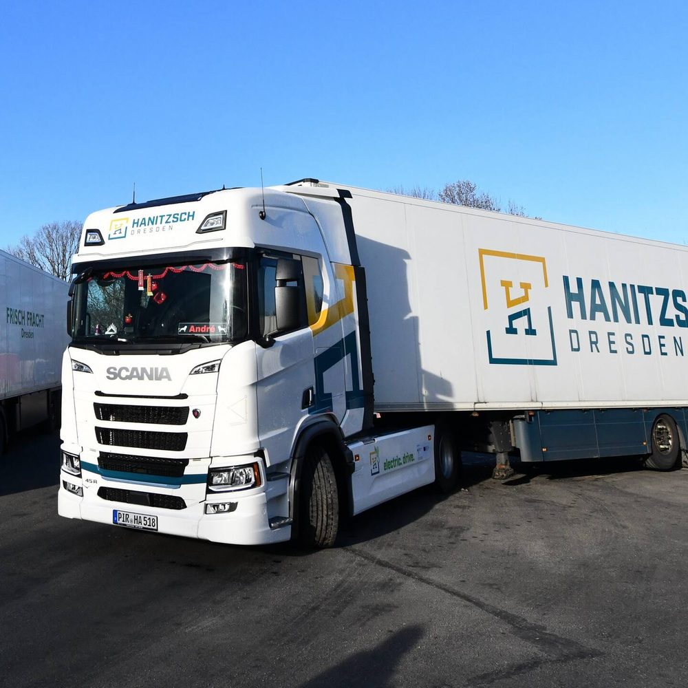 Weißer vollelektrischer Scania Sattelzug der Spedition Hanitzsch mit Schriftzug electric drive